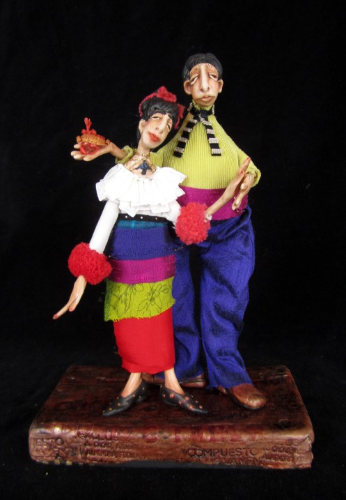 Frida and Diego Portrait ... Wearing her famous hummingbird necklace and Diego holding a milagro represtenting one of Frida's painted hearts ... this is the first in a series I will do over time of this famous couple ... they are standing on a printed polymer surface created from the metal stamp for an old chocolate factory in St Louis Potosi, a town near where we stay in the winter in Mexico ... 9" tall ... 595.00